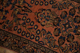 Dusty raspberry Lilihan rug with ornate navy and beige floral patterns and a section of border.