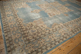 Vintage Sparta rug corner with cream curvilinear border and dusty blue spandrel.