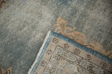 Folded corner of vintage Sparta carpet showing hand-knotted foundation, cream fringe, and blue side cord.