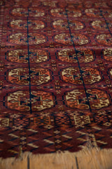 Antique Turkmen rug displaying burgundy, navy, apricot elephant's footprint guls and worn fringe.