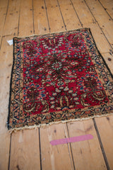 Vintage Persian Lilihan rug with cherry red floral bouquet, scrolling vines, and fringed borders.