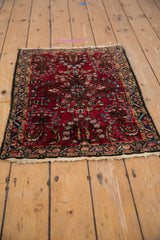Vintage Lilihan rug corner, cherry red floral field, vine palmette border, tattered fringe.