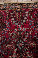 Vintage Lilihan rug with cherry red field, delicate blue floral vines, minor border, and fringe.