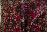 Hand-knotted vintage Lilihan rug with cherry red pile, blue floral motifs, scrolling vines.