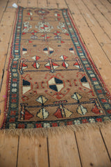 Close-up of antique Northwest Persian runner, showing camel brown field with madder red pinwheel motifs.