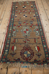Antique Northwest Persian runner's camel brown field, pinwheel floral motifs, and geometric border.