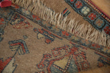Hand-knotted fringe and re-secured edge of antique Persian runner, with camel, red, and blue motifs.