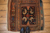 Antique Afshar rug showing central medallion, dragon florals in navy, terracotta, teal tones.