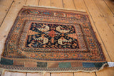 Antique Afshar rug's lower left corner, featuring terracotta borders, navy field, and pomegranate guls.