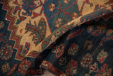 Folded Borchalou rug showing the navy pile against the geometric design of its foundation.