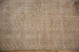 A close view of the even, short pile revealing serrated geometric designs in sand and ivory tones.