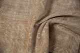 Soft, even pile and distressed geometric patterns on a vintage Turkmen rug in sand and beige tones.