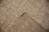 A folded corner of the vintage Turkmen rug revealing its hand-knotted foundation and side cord.