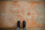 Distressed vintage Kurd runner rug, primitive geometric pattern, short pile, tangerine and ivory tones.