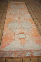 Vintage Distressed Kurd runner showing geometric starburst guls, hook motifs, and end fringe.