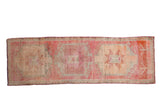 Distressed vintage Kurd runner with triple geometric medallions in fuchsia, rose, and silvery tones.