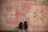 Overhead detail of a distressed Kurd rug showing the short pile and abrashed fuchsia and silver tones.