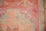 Close-up of a distressed Kurd rug's short pile with a raspberry hook motif.