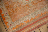 Distressed texture of hand-knotted Kurd runner, showing wear and tangerine zig zag border.