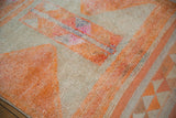 Distressed tangerine orange, ivory, and fuchsia geometric pattern on a vintage Kurd rug runner.