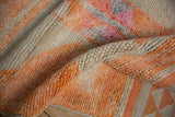 Textural folds of tangerine orange and ivory distressed Kurd hand knotted pile.