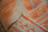 Distressed tangerine orange pile and geometric plain weave back of a vintage Kurd runner.
