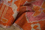 Textured view of the distressed pile showing knot heads in tangerine orange and fuchsia.