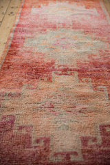 Soft, textured pile of a distressed Kurd rug runner with abrashed dusty raspberry red tones.