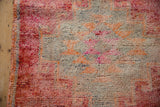 A close-up view of the hand-knotted pile and intact side cord on a vintage distressed Kurd rug.