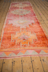A long perspective view of the distressed Kurd runner's geometric pattern in orange and red.