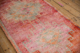 Close view of the distressed, even pile on a Kurd runner in raspberry red and silver.