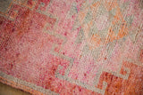 Softly distressed wool pile of a vintage Kurd rug in abrashed raspberry and tangerine orange.
