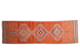 Vintage distressed Kurd runner, tangerine orange with pink and purple checkerboard medallions.