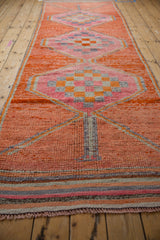 Distressed vintage Kurd runner, abrashed tangerine ground with checker motif medallion.