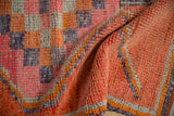 Distressed vintage Kurd runner with folded texture highlighting pink, tangerine, purple, silver border.