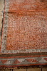 Distressed orange field texture with geometric border motif on vintage Kurd runner.