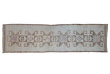 Vintage distressed Kurd runner with a single column of dramatic starburst medallions in camel, ivory, and mauve.
