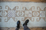 Looking down at the textured starburst designs on a distressed vintage Kurd runner rug.