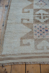 Detail of a Kurd rug's macrame selvage, distressed low pile, and checkered pinwheel pattern.