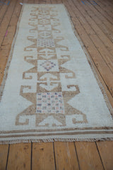 Angled view of a vintage distressed Kurd runner with its repeating starburst pattern.