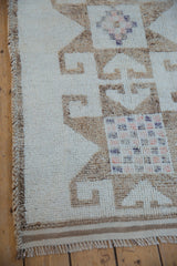 Distressed wool pile showing a checkered pinwheel motif next to a macrame selvage.