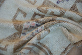 A vintage Kurd rug folded to reveal a soft, distressed pile with visible knots and texture.