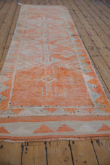 Textured detail of the distressed Kurd runner with geometric tangerine patterns and chevron border.