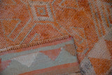 Textured short pile of vintage distressed Kurd rug runner in tangerine orange, silver, and striped foundation.