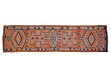 Vintage Kurd runner with interconnected navy medallions on a distressed tangerine orange field.