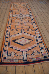 Intact side cord selvage and navy blue geometric border of a distressed Kurd runner.