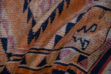 Even wear across the tangerine and navy blue knot heads of a vintage distressed Kurd rug runner.