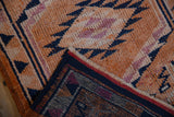 Hand-knotted weave and distressed pile texture visible on a vintage Kurd runner's folded corner.