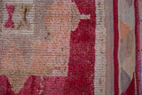 Distressed Kurd rug pile: fuchsia, red, and beige tones with visible knot heads and variegated selvage.