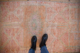 Distressed texture of a vintage Kurd runner with pink, tangerine, and ivory tones.